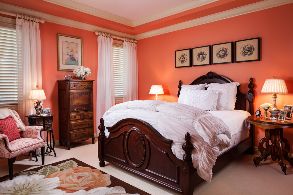 Immagine di una camera da letto chic con pareti arancioni e moquette