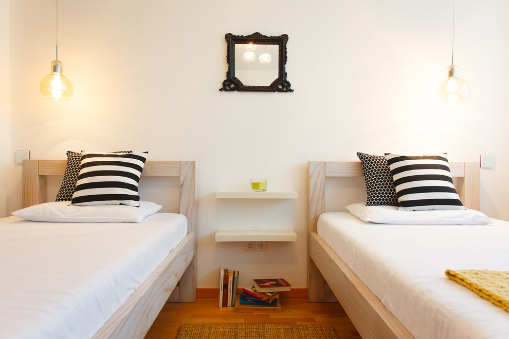 Esempio di una grande camera degli ospiti minimal con pareti bianche, pavimento in legno massello medio e pavimento marrone