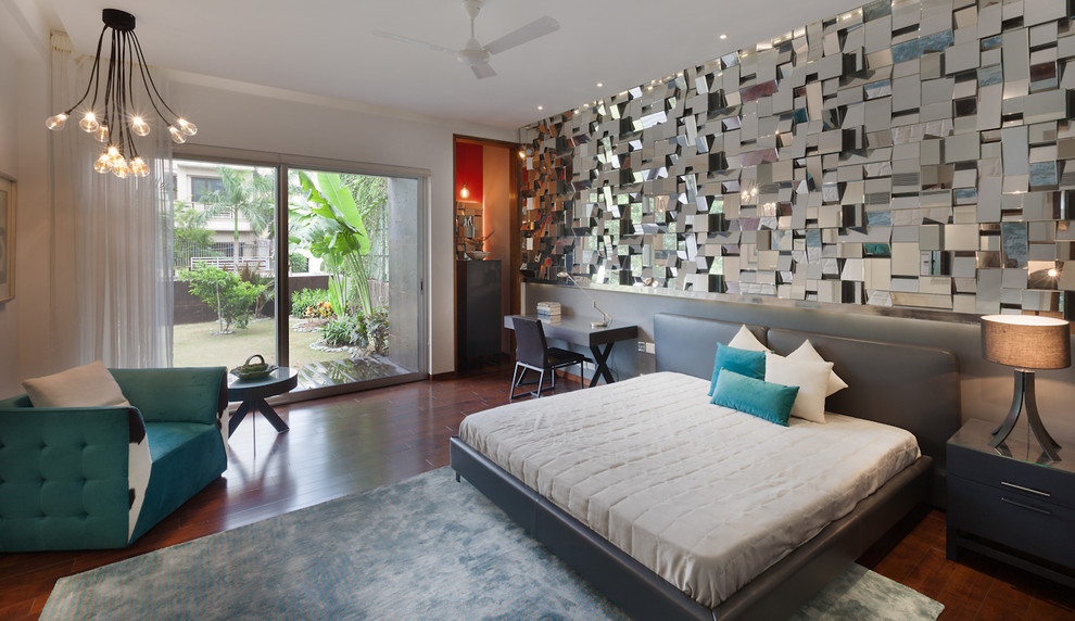 Cette image montre une chambre parentale design avec un mur blanc, parquet foncé et un sol marron.