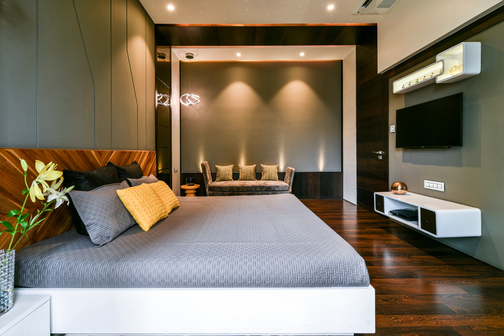 Modernes Schlafzimmer ohne Kamin mit grüner Wandfarbe, dunklem Holzboden und braunem Boden in Mumbai