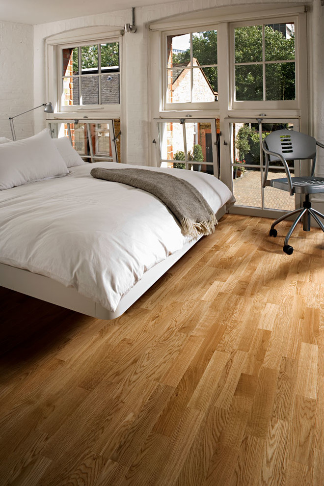 Cette photo montre une chambre d'amis scandinave de taille moyenne avec un mur blanc et un sol en bois brun.