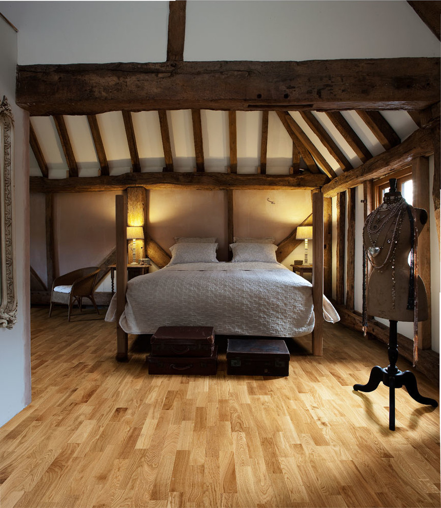Foto di una camera da letto stile loft stile americano di medie dimensioni con pareti bianche e pavimento in legno massello medio