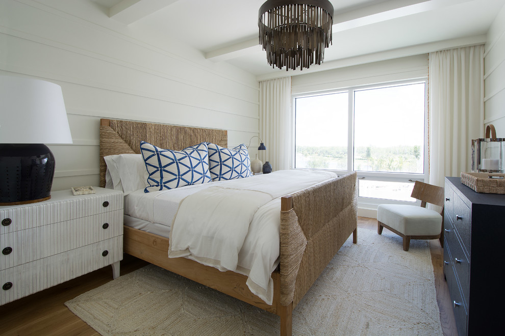 Foto di una camera da letto costiera con pareti bianche, pavimento in legno massello medio e pavimento marrone