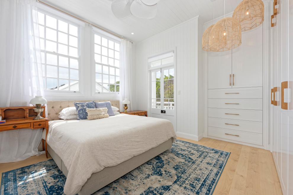 Schlafzimmer mit weißer Wandfarbe, hellem Holzboden, beigem Boden, Holzdielendecke und Holzdielenwänden in Brisbane