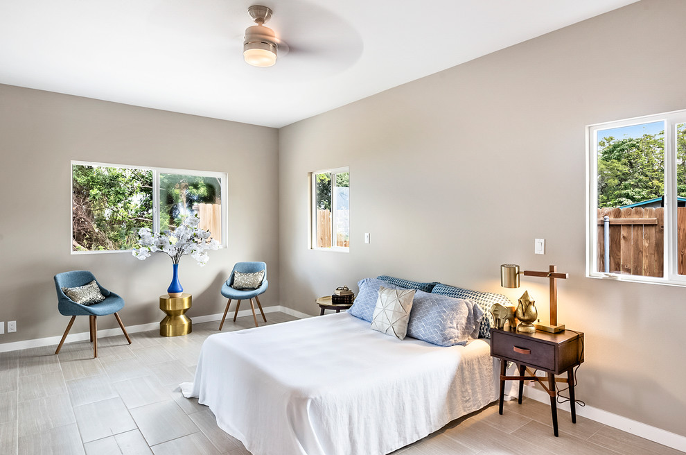 Ejemplo de habitación de invitados retro de tamaño medio con paredes beige, suelo de baldosas de cerámica y suelo beige