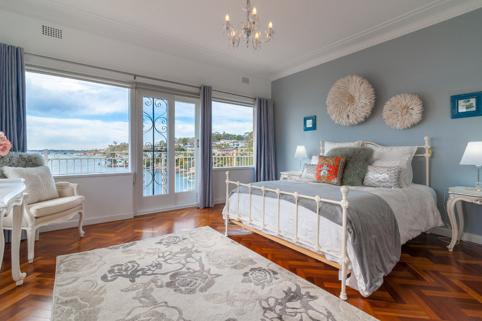 シドニーにあるトラディショナルスタイルのおしゃれな寝室 (白い壁、無垢フローリング、茶色い床、青いカーテン、グレーとブラウン) のレイアウト