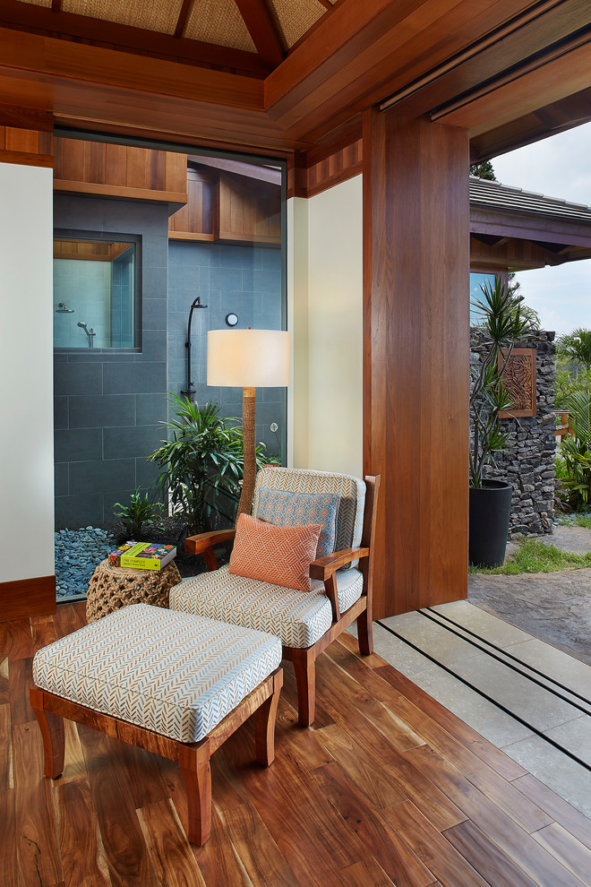 Großes Schlafzimmer ohne Kamin mit braunem Holzboden und beiger Wandfarbe in Hawaii