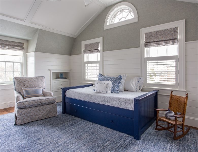 Example of a mid-sized transitional loft-style medium tone wood floor and blue floor bedroom design in Boston with gray walls and no fireplace