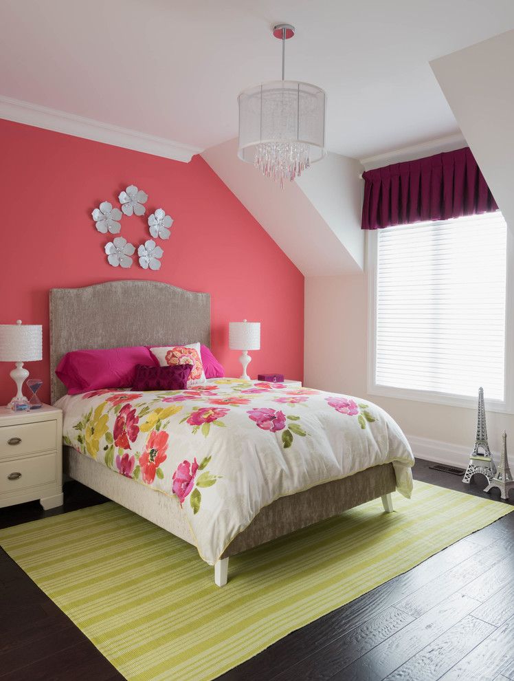 Aménagement d'une chambre classique avec un mur rose et parquet foncé.