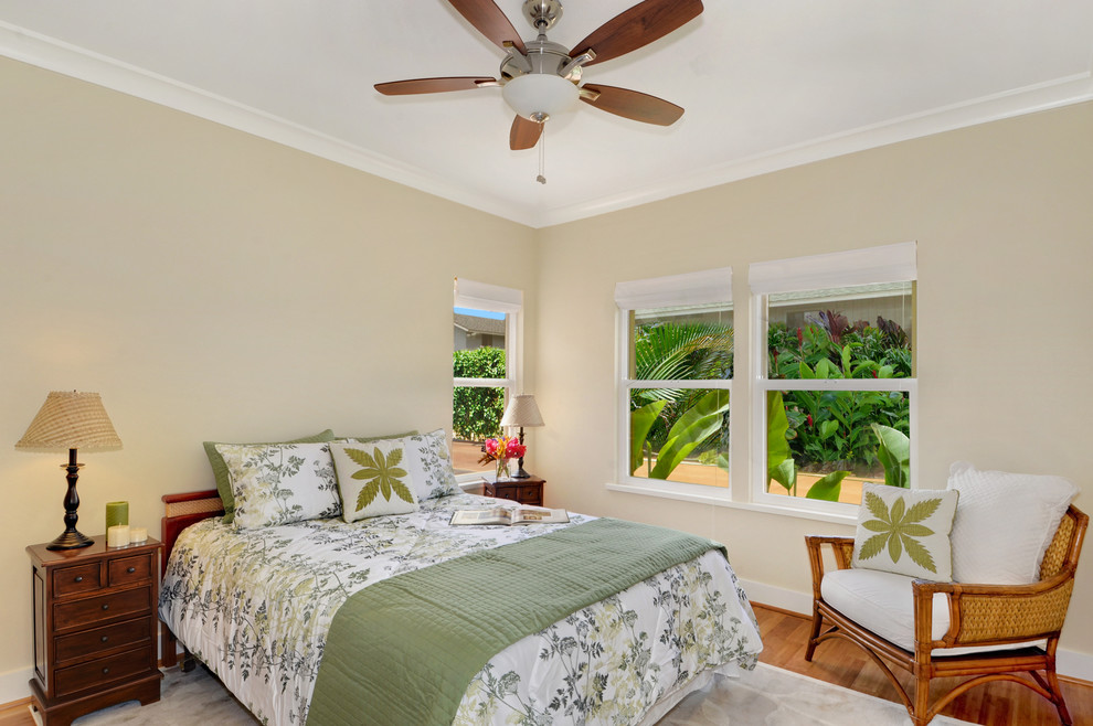 Esempio di una camera degli ospiti tropicale di medie dimensioni con pareti beige, pavimento in legno massello medio, nessun camino e pavimento marrone