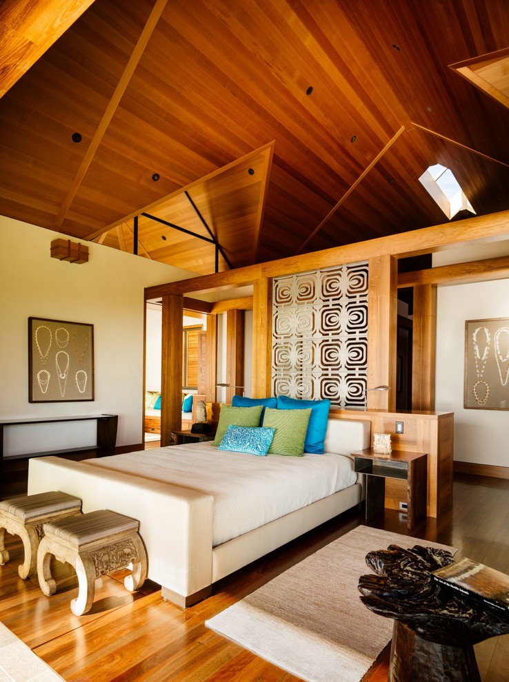 Idee per una camera da letto tropicale con pareti beige, pavimento in legno massello medio e pavimento marrone