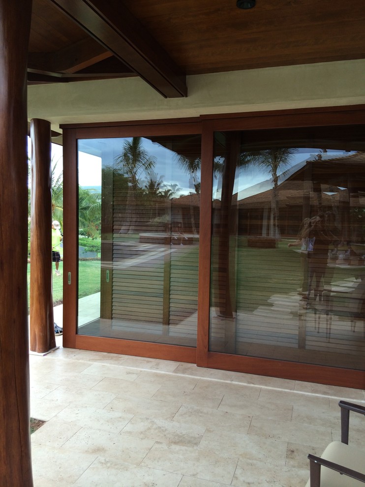 Bild på ett stort tropiskt huvudsovrum, med beige väggar och travertin golv