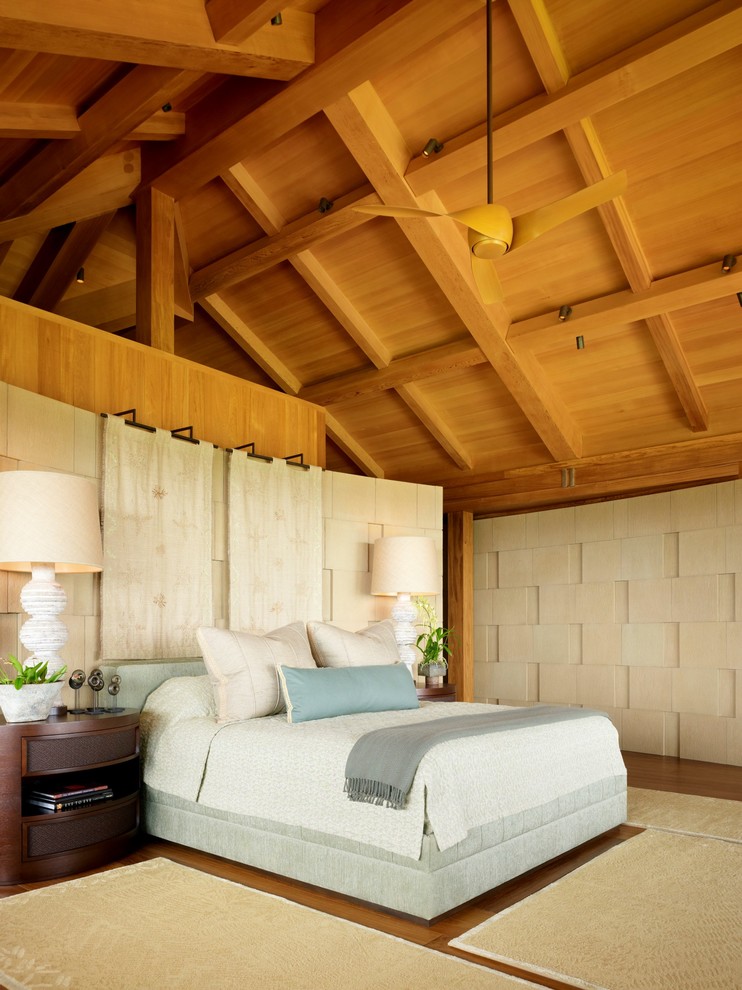 Imagen de dormitorio principal tropical con paredes beige, suelo de mármol, suelo marrón y techo inclinado