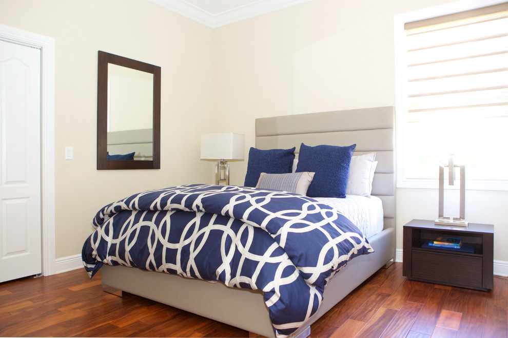 Imagen de habitación de invitados actual pequeña con paredes beige y suelo de madera en tonos medios