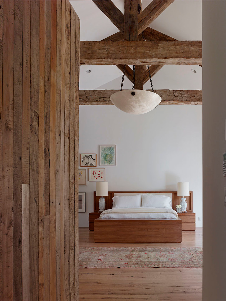 Inspiration för ett rustikt sovrum, med vita väggar och mellanmörkt trägolv