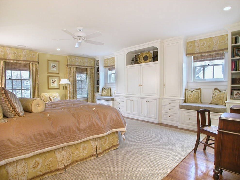 Idee per una camera da letto tradizionale con pareti beige e pavimento in legno massello medio