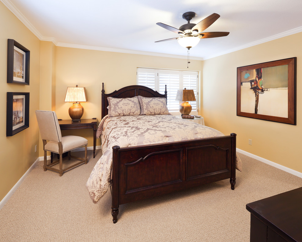 Modelo de dormitorio principal tradicional de tamaño medio sin chimenea con paredes amarillas, moqueta y suelo beige