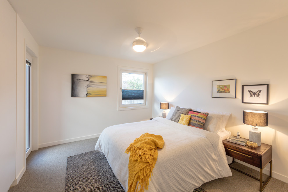 На фото: маленькая гостевая спальня (комната для гостей) в современном стиле с белыми стенами, ковровым покрытием и разноцветным полом для на участке и в саду с