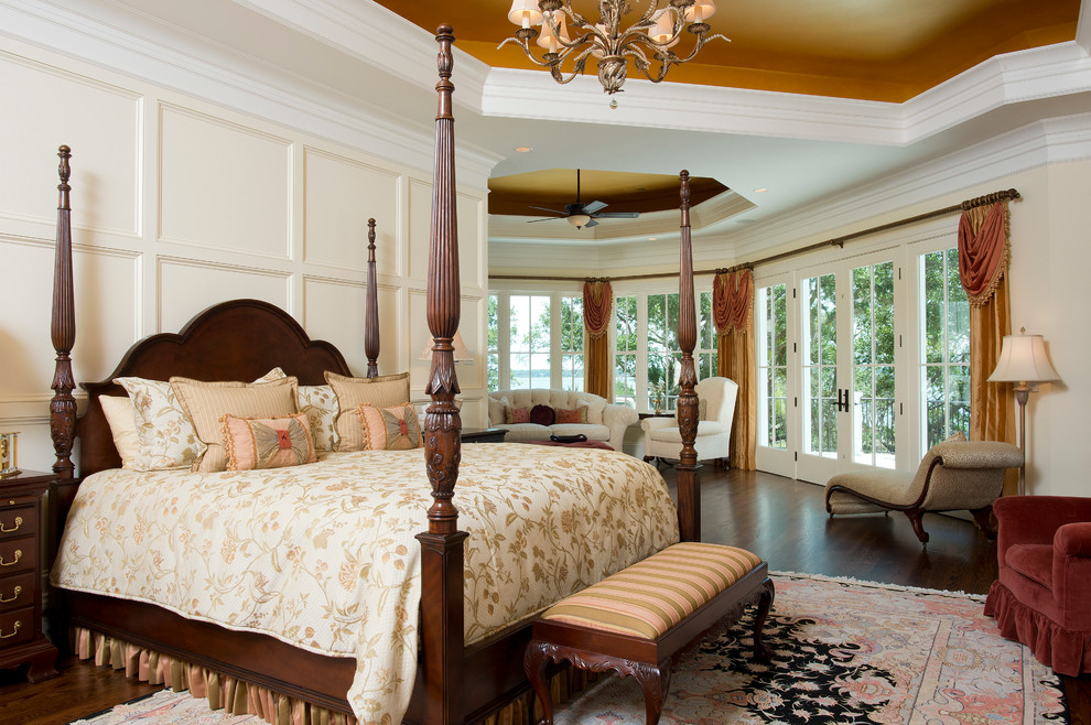 Ispirazione per un'ampia camera matrimoniale classica con pareti beige e pavimento in legno massello medio