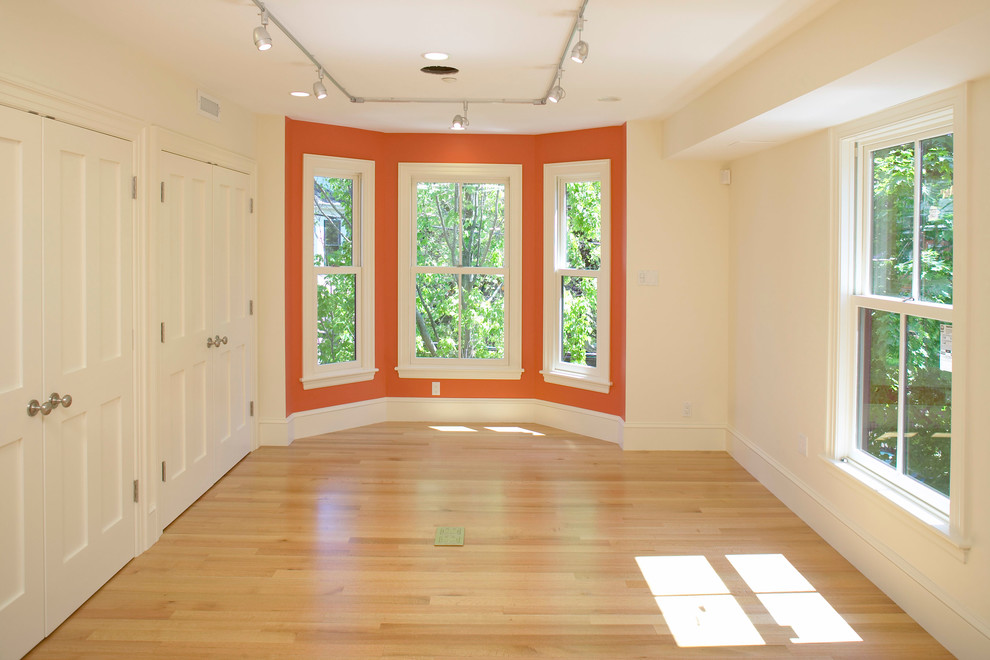 Cette image montre une chambre traditionnelle de taille moyenne avec un mur beige, parquet clair et aucune cheminée.