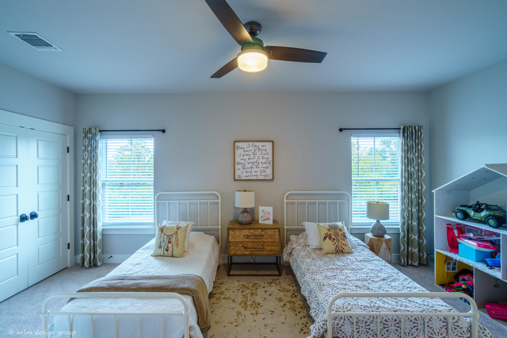 Foto på ett stort lantligt sovrum, med grå väggar, heltäckningsmatta och grått golv