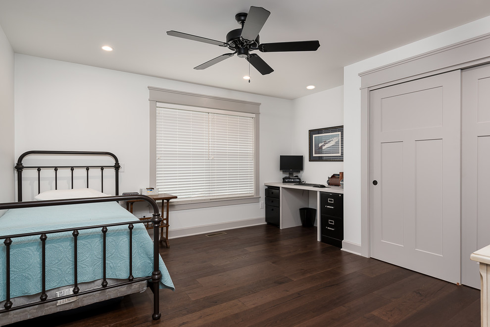 Modelo de habitación de invitados clásica renovada, de tamaño medio, con paredes azules, suelo de madera en tonos medios y suelo marrón