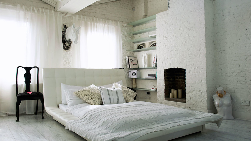 Kleines Modernes Hauptschlafzimmer mit weißer Wandfarbe, hellem Holzboden, Kamin und Kaminumrandung aus Backstein in London