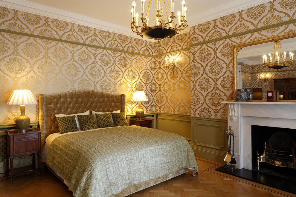 Klassisches Hauptschlafzimmer mit bunten Wänden, braunem Holzboden und Kamin in London