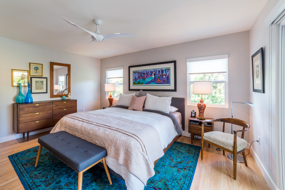 Foto de dormitorio principal retro grande con paredes blancas, suelo de madera en tonos medios y suelo marrón