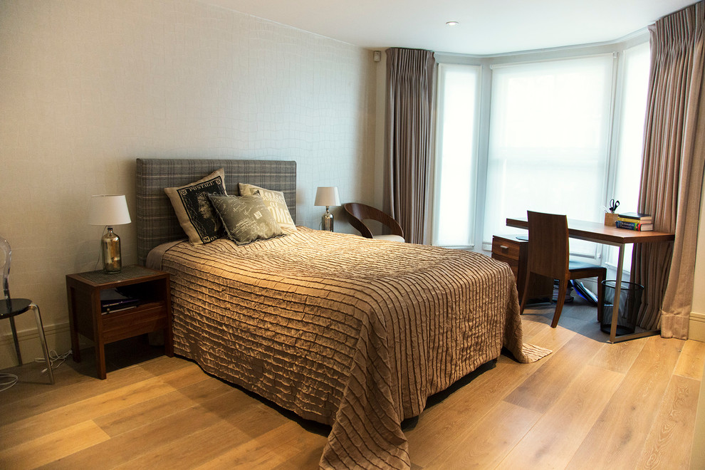 Example of a mid-sized classic light wood floor bedroom design in London with white walls