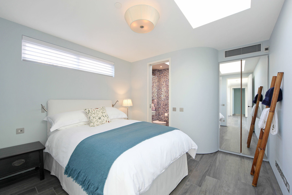 Mittelgroßes Modernes Hauptschlafzimmer mit blauer Wandfarbe und grauem Boden in London