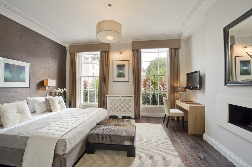 Klassisches Hauptschlafzimmer mit weißer Wandfarbe, dunklem Holzboden und Gaskamin in West Midlands