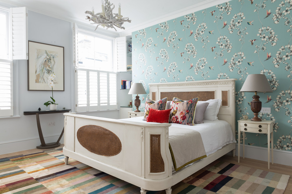 Foto di una camera da letto chic con pareti blu e parquet chiaro