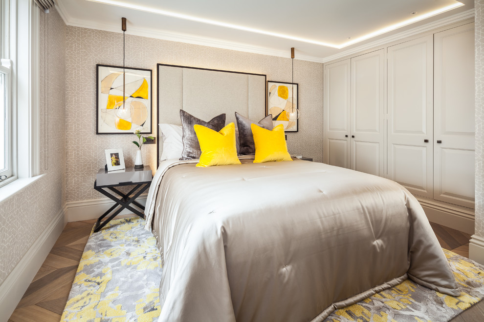 This is an example of a medium sized traditional grey and brown bedroom in London with medium hardwood flooring and brown floors.