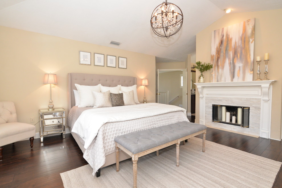 Foto di una camera da letto chic con pareti beige, parquet scuro, camino classico e pavimento marrone