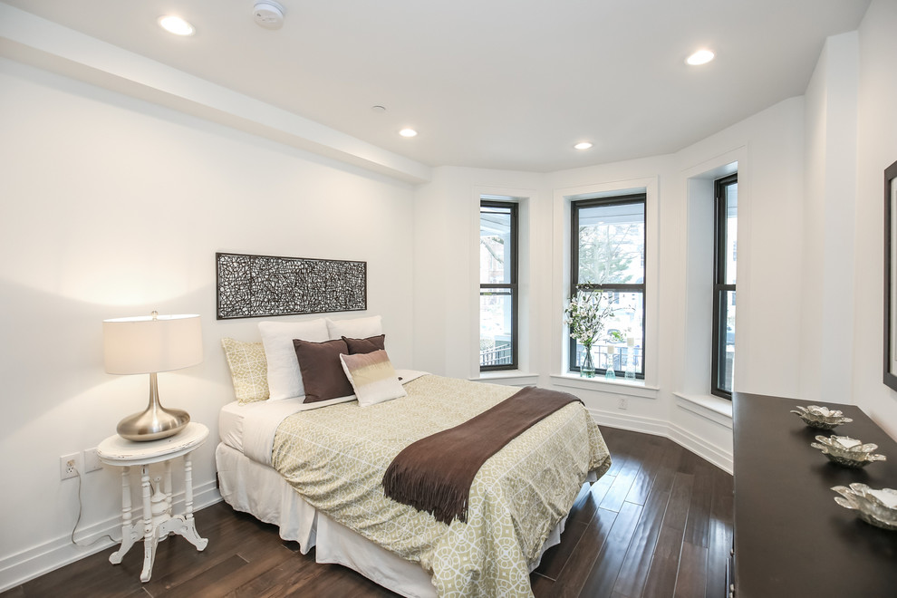 Modelo de habitación de invitados tradicional renovada de tamaño medio con paredes blancas y suelo de madera oscura