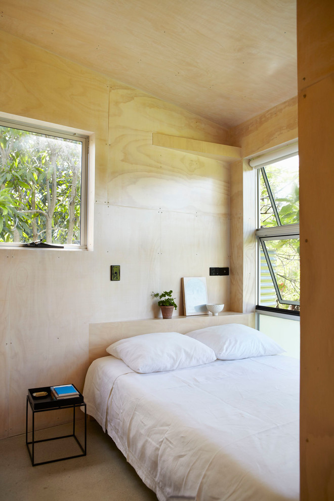 Inspiration pour une petite chambre parentale design avec sol en béton ciré et un mur beige.