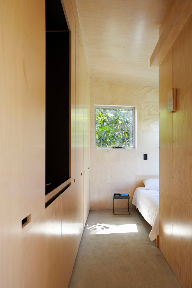 Small urban master concrete floor and gray floor bedroom photo in Sunshine Coast with beige walls