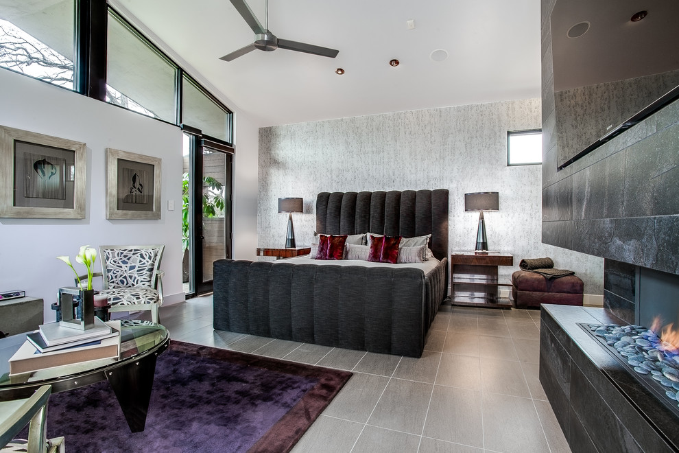 Стильный дизайн: большая хозяйская спальня в современном стиле с серыми стенами, серым полом, горизонтальным камином и фасадом камина из камня - последний тренд