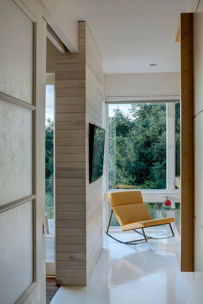 Imagen de dormitorio principal minimalista de tamaño medio con paredes blancas, suelo de cemento y suelo blanco