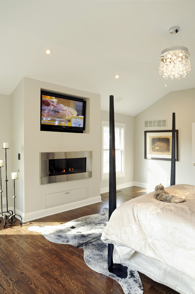 Modelo de habitación de invitados actual de tamaño medio sin chimenea con paredes grises y suelo de madera en tonos medios