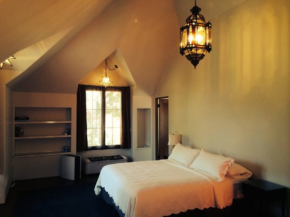 Modelo de habitación de invitados clásica de tamaño medio sin chimenea con paredes beige, suelo de madera oscura y suelo marrón