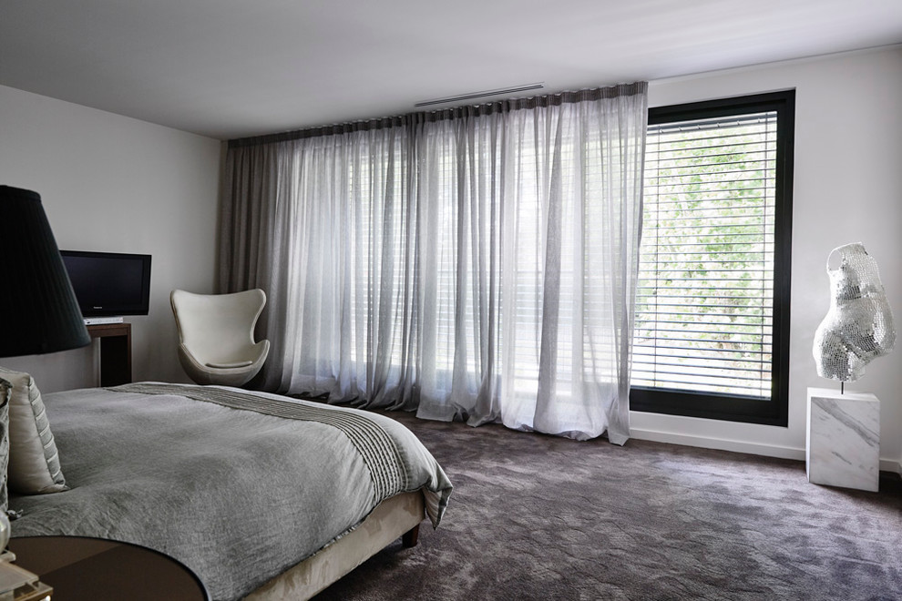 Идея дизайна: хозяйская спальня в стиле модернизм с белыми стенами и ковровым покрытием без камина
