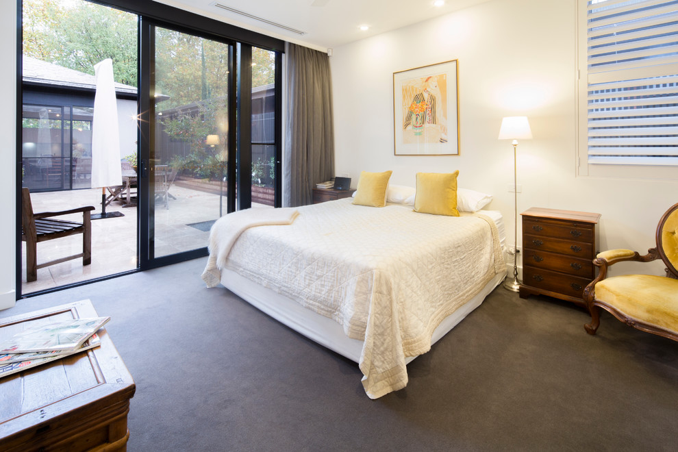 Medium sized modern master bedroom in Melbourne with white walls and carpet.