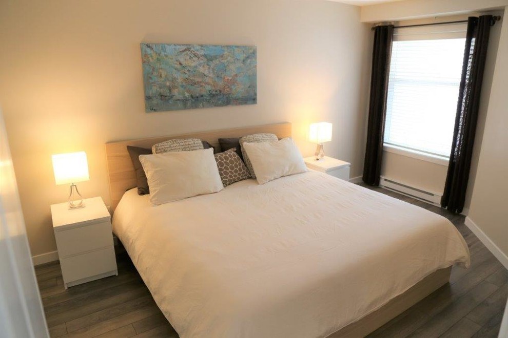This is an example of a small contemporary master bedroom in Vancouver with laminate floors and grey floors.
