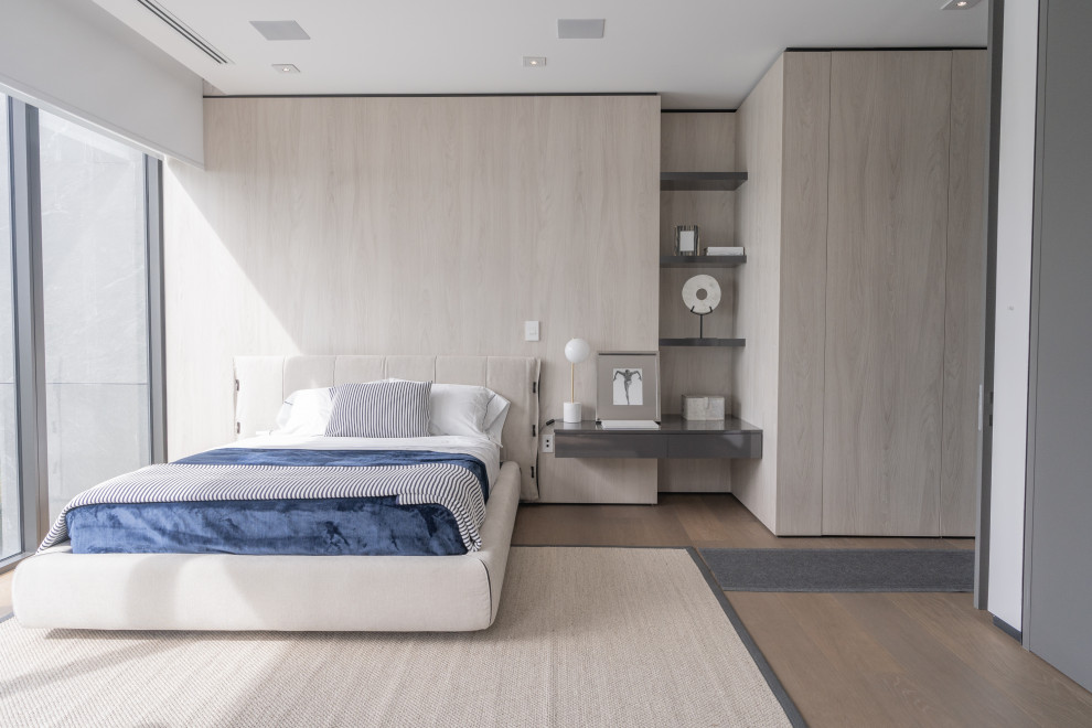 Trendy medium tone wood floor, beige floor and wood wall bedroom photo in Miami with beige walls