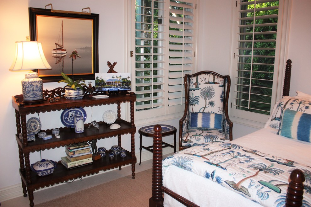 Immagine di una camera degli ospiti tropicale di medie dimensioni con pareti beige e moquette
