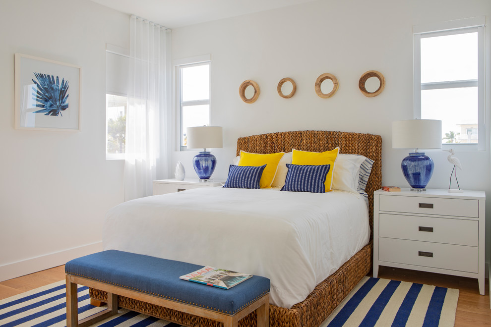 マイアミにある中くらいなビーチスタイルのおしゃれな客用寝室 (白い壁、暖炉なし、無垢フローリング、茶色い床) のレイアウト