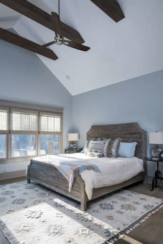 Пример оригинального дизайна: большая хозяйская спальня в стиле кантри с синими стенами, темным паркетным полом и коричневым полом без камина