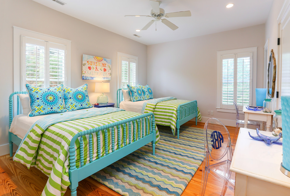 Foto de habitación de invitados costera con paredes beige, suelo de madera en tonos medios y con escritorio